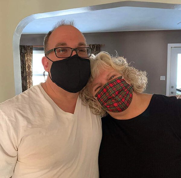 Susan - Susan Laying Her Head on a Mans Shoulder While Standing in a House With Masks on